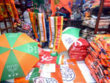 A vendor sells flags and umbrellas printed with the symbols of different political parties at a market ahead of Lok Sabha Polls, in Kolkata.
